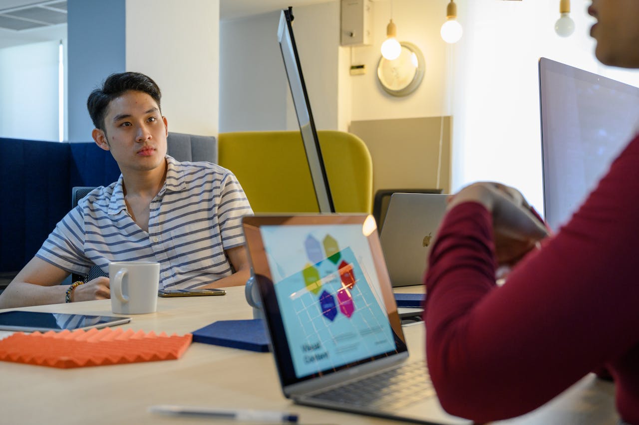 Casual business meeting in a modern office with technology and discussion.